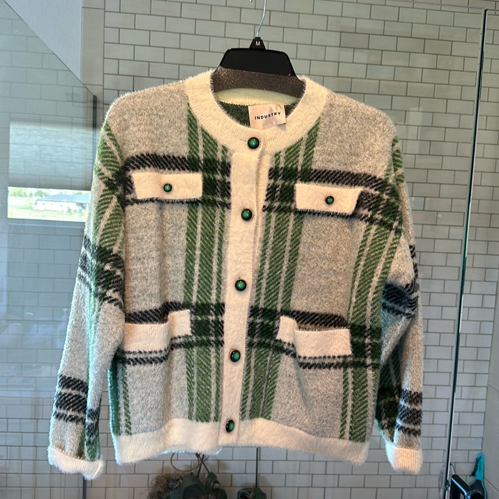 White cardigan sweater with green plaid design, and emerald buttons